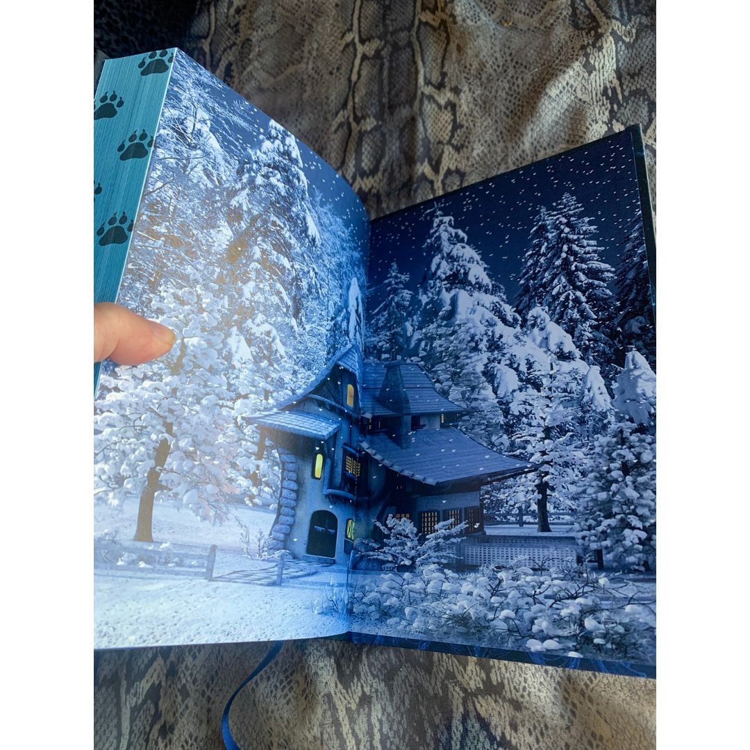 book open to a snowy scene with a house and trees